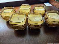All six square yellow glass votive candles