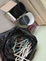 Full lot with bag of hangers, bed risers in box, two wastebaskets, dumbbells visible