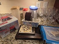 overall lot showing fondue set box, plastic canisters, pitcher, cheese board, ceramic dish, cheese slicer box and wine glasses