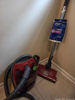 Overall view of canister vacuum, hose, wand, powerhead, vacuum bag pack
