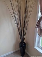 Full view of vase with sticks placed in corner