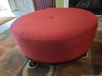 Angled view showing red quilted microfiber upholstery and wood base