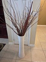Full view of tall white vase with branches