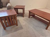 Three mission-style wooden tables: two side tables, one coffee table