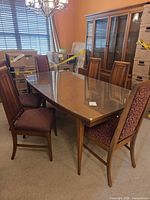 Full view of dining table with glass top and surrounding chairs
