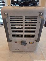 Front view showing grille, thermostat knob, power switch, caution light, Patton logo