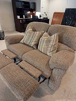 Front view of loveseat with footrests extended and pillows in place
