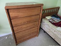 Full view of dresser beside twin bed frame and mattress