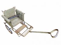 Angled view of full stroller showing wicker body, wheels, pull handle