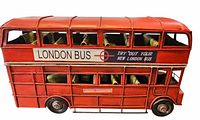 Left side view of red metal London bus model showing signage and seating