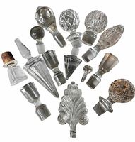 Thirteen assorted crystal and glass stoppers arranged in radial pattern
