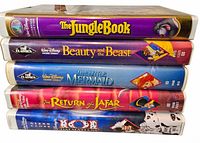 Front spines of all five Disney VHS tapes stacked