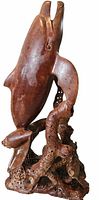 Full view of wood sculpture showing dolphin and coral base