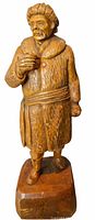 Front view of carved wooden figure on base