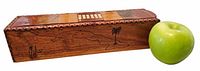 Slide-top wooden box beside apple for scale, showing hand-burned map of Cuba and scalloped edge