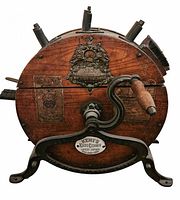 Front view showing Kent emblem, crank, wood drum, cast iron frame