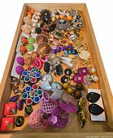 Tray containing multicolored vintage costume jewelry pieces