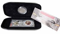 Open display case showing encapsulated coin, stamp pane, and booklet