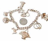 Full view of bracelet with six charms and quarter for scale