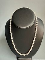 Full view of pearl necklace on bust form