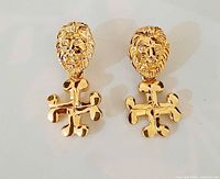 Front view of both Anne Klein lion head cross earrings