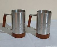 Two matching pewter tankards showing overall shape, handles, bases