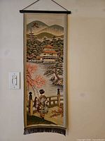 Full view of tapestry hanging on wall showing complete design, rod, cord and fringe
