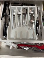 Flatware tray with forks, spoons, steak knives and surrounding utensils
