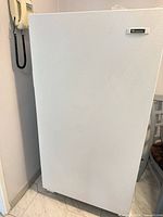 Front view of white upright freezer closed