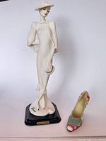 Full view of porcelain figurine and separate floral shoe