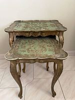 two ornate gold and green nesting tables stacked