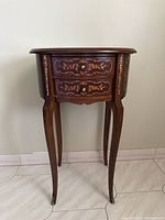 Front view showing two drawers, marquetry, brass mounts, cabriole legs