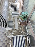 Top view of glass table and four striped-cushion chairs