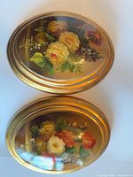 Front view showing both oval floral artworks in gold frames