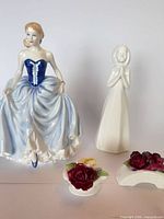 Group shot of all four items: Susan figurine, praying girl figurine, two floral pieces