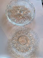 Both clear pressed glass platters, top view showing patterns