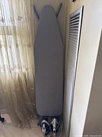 Ironing board with two irons stored at base