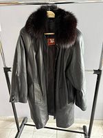 Front view of black Wall leather coat with fur collar on hanger