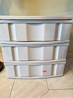 Front view showing three white plastic drawers