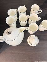 Top view showing teapot, lid, and eight mugs