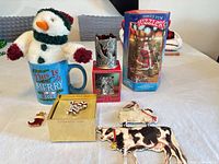 Group overview of mug with plush, candle holder, puzzle, pins, ornaments, books