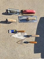 All seven concrete hand tools laid out on concrete surface