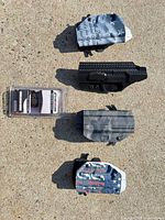 Group shot of four Kydex holsters and sealed bore cleaner