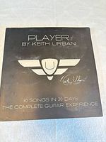 Front of black "Player by Keith Urban" box showing title and logo