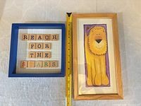 Front view of framed sign and lion illustration with measuring tape for scale