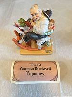 Front angled view of figurine with pamphlet