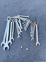 Assorted wrenches spread on pavement
