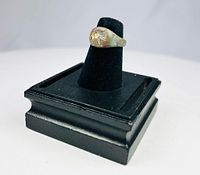 Bronze ring on display stand front view showing elephant motif