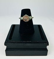 Front view of bronze signet ring on black stand