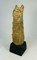 Front view of linen-wrapped cat mummy on black base